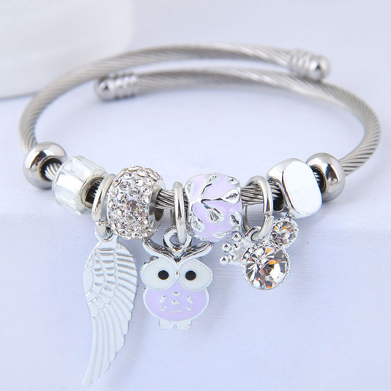 Bracelet en acier inoxydable orné d'un pendentif de chouette et d'ailes d'ange.
