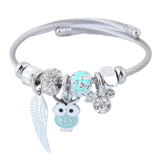 Bracelet en acier inoxydable orné d'un pendentif de chouette et d'ailes d'ange.