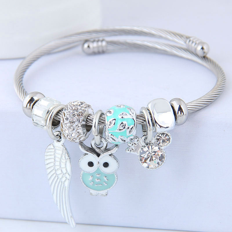 Bracelet en acier inoxydable orné d'un pendentif de chouette et d'ailes d'ange.