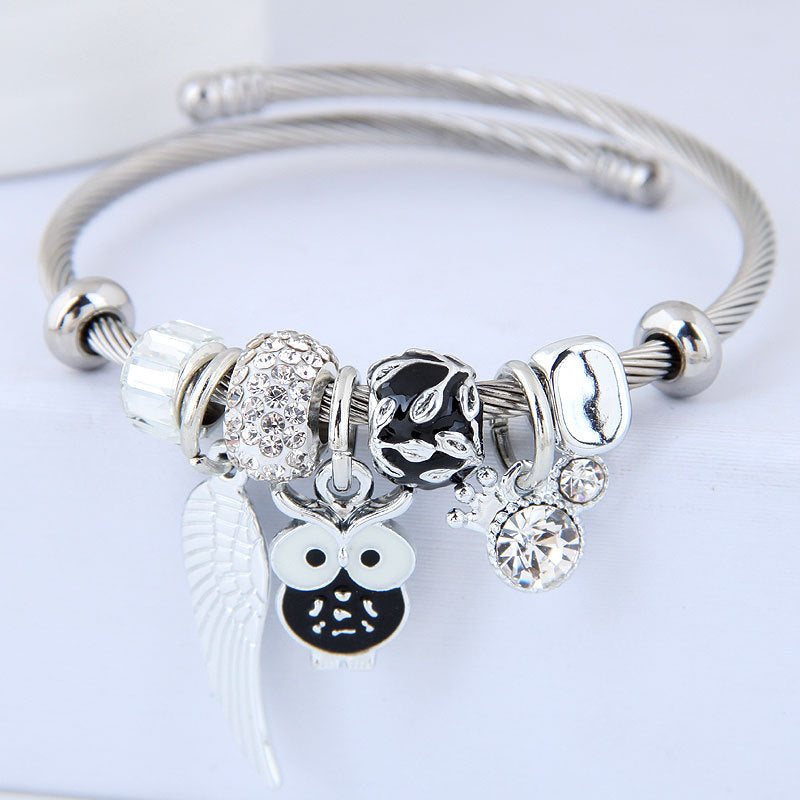 Bracelet en acier inoxydable orné d'un pendentif de chouette et d'ailes d'ange.