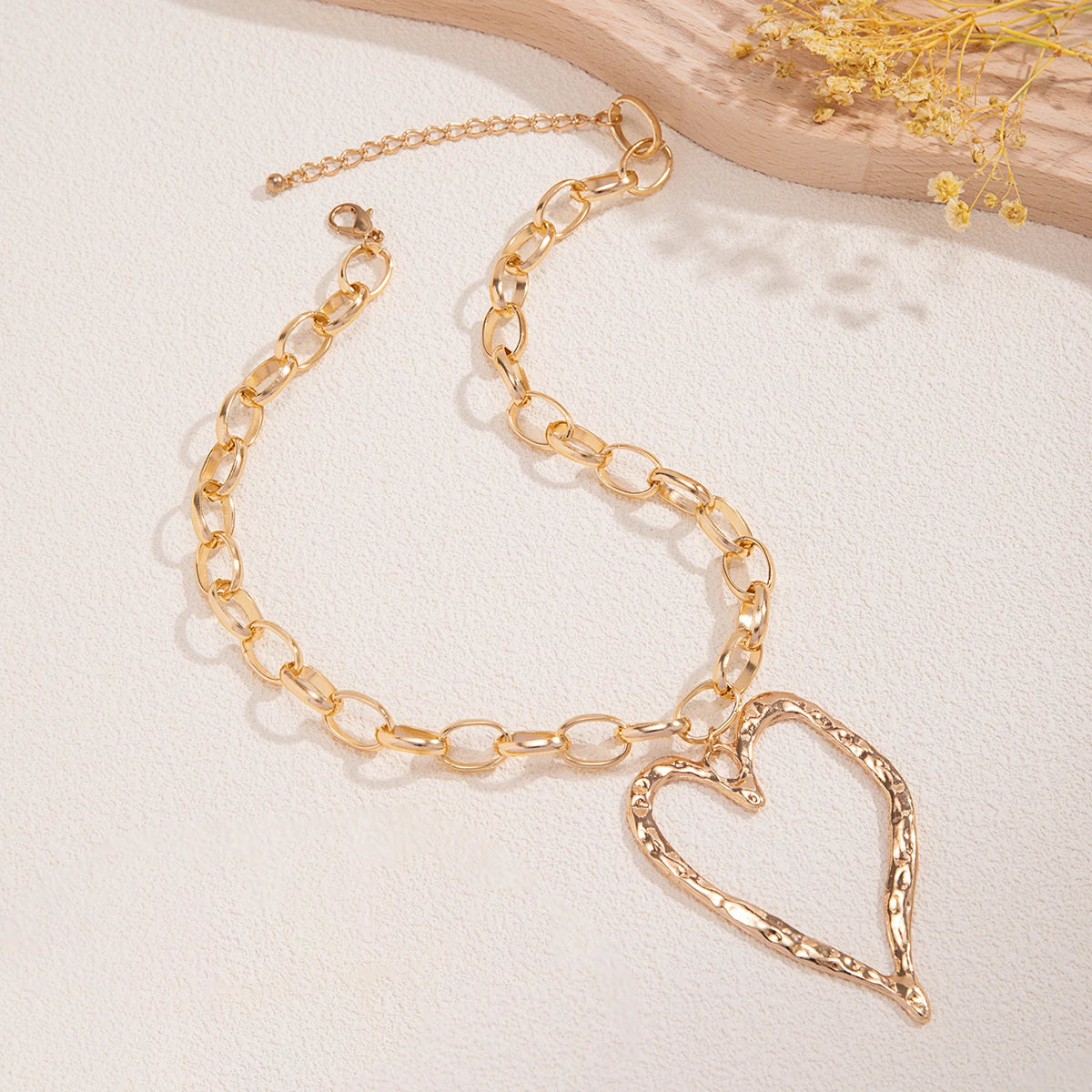 Collier cœur à motif creux et à chaînes épaisses.