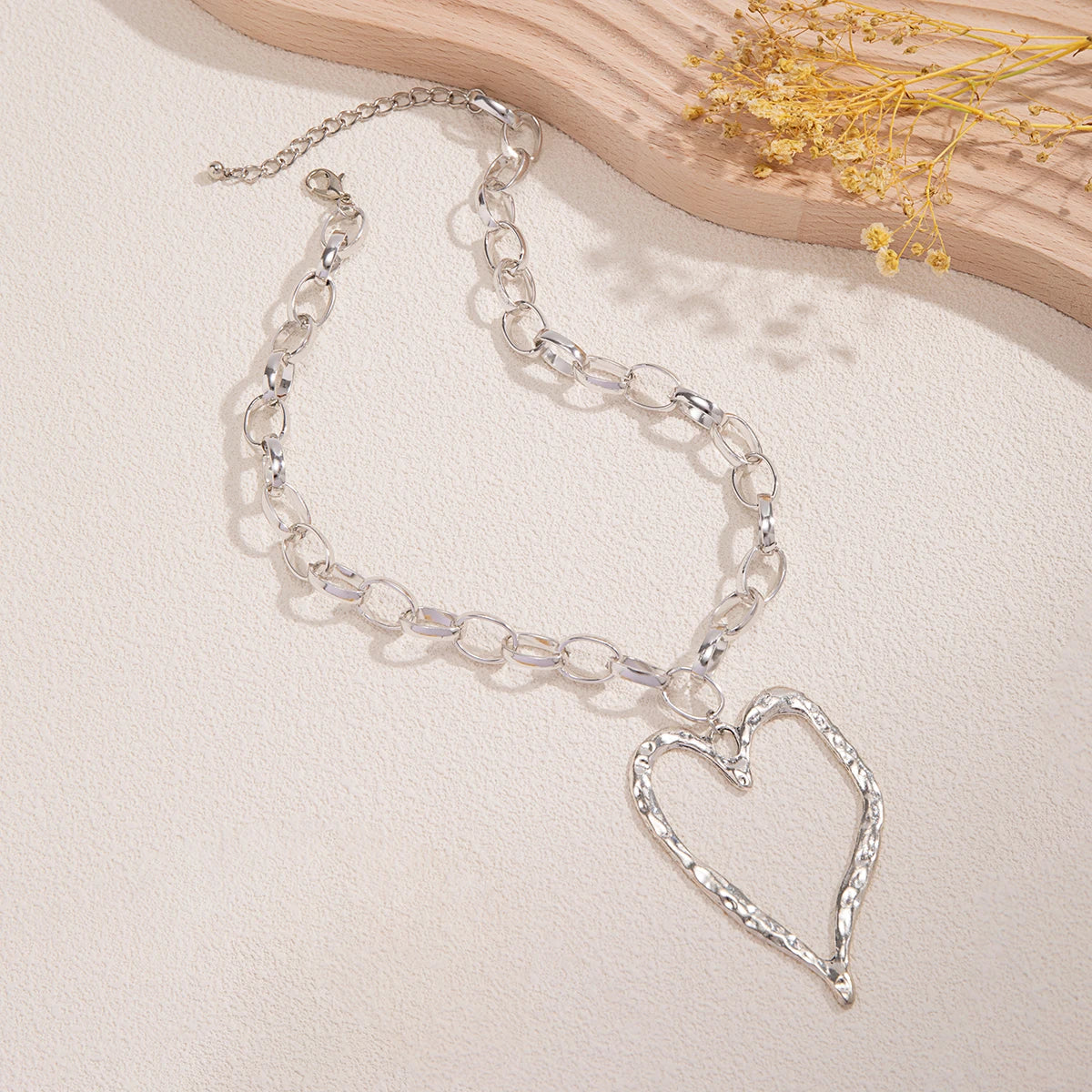 Collier cœur à motif creux et à chaînes épaisses.
