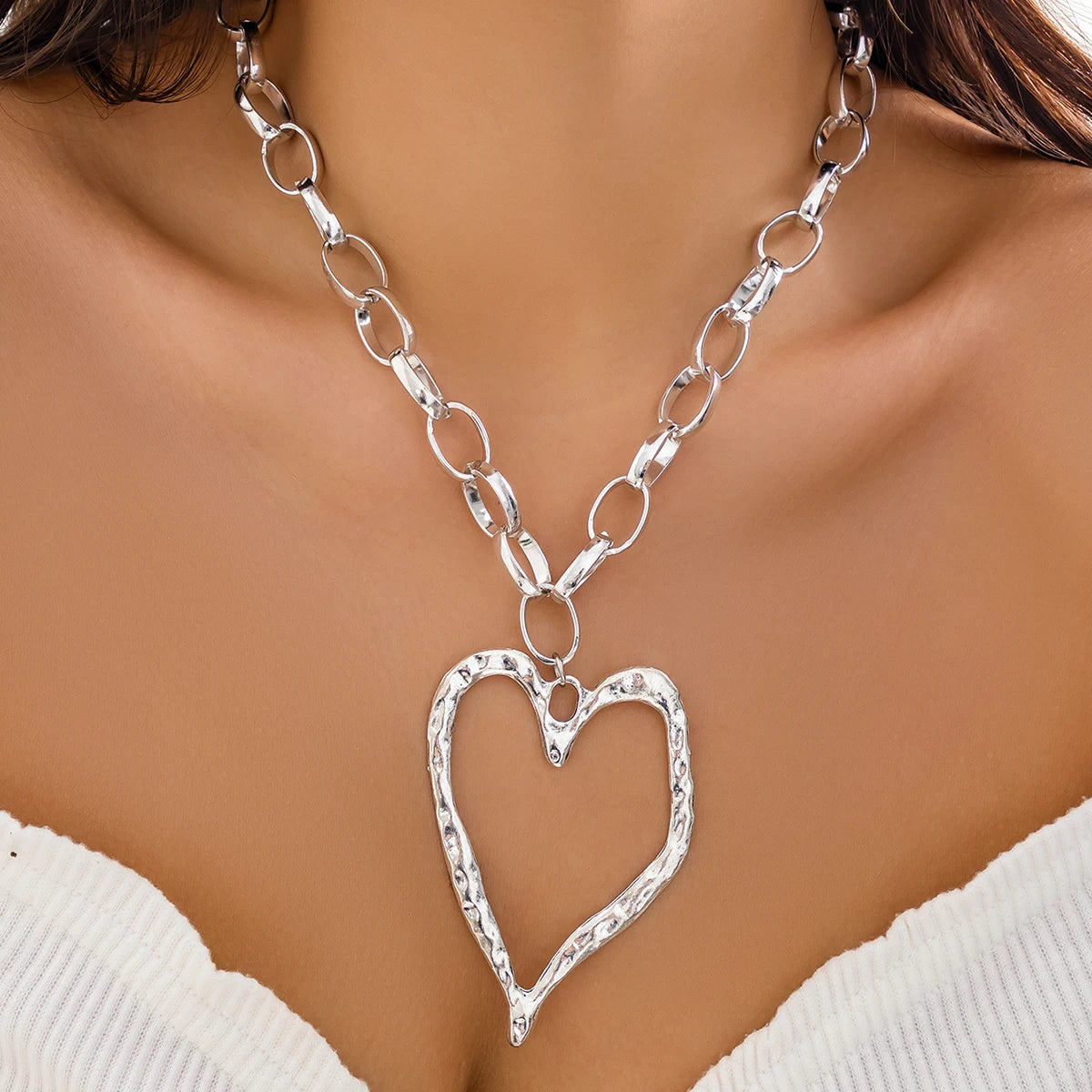 Collier cœur à motif creux et à chaînes épaisses.