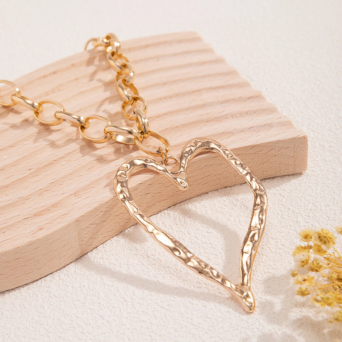Collier cœur à motif creux et à chaînes épaisses.