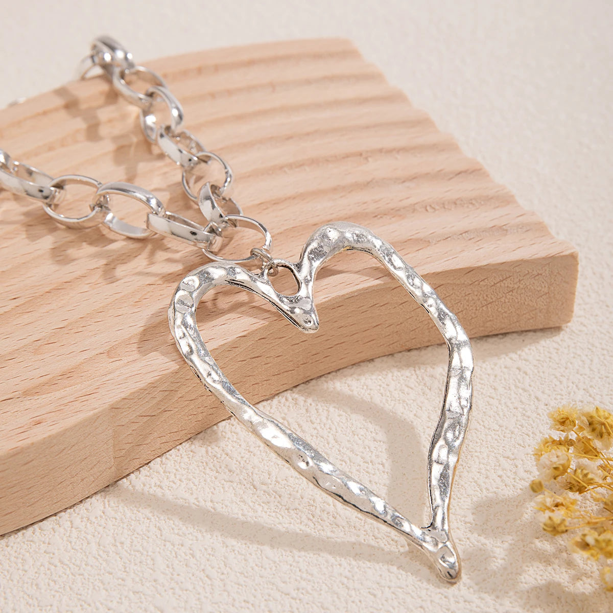 Collier cœur à motif creux et à chaînes épaisses.