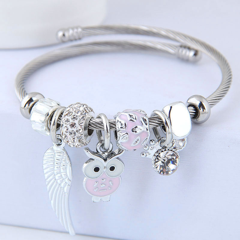 Bracelet en acier inoxydable orné d'un pendentif de chouette et d'ailes d'ange.