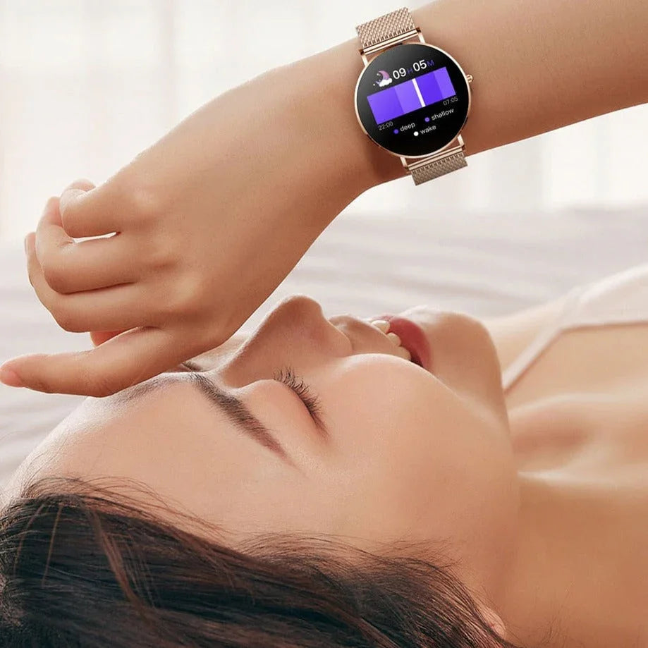 Femme détendue portant une montre connectée dorée affichant le suivi du sommeil au poignet